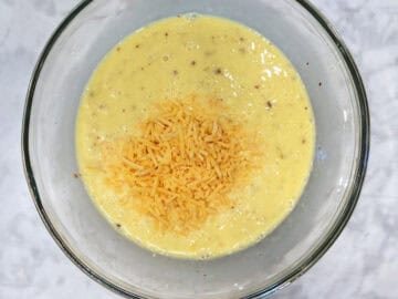 Adding cheese to the egg mixture.