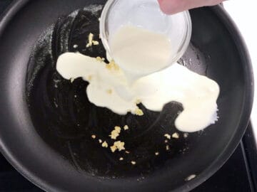Adding heavy cream to the skillet.