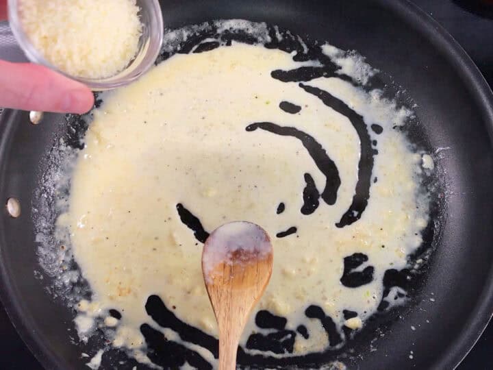 Adding parmesan to the sauce.