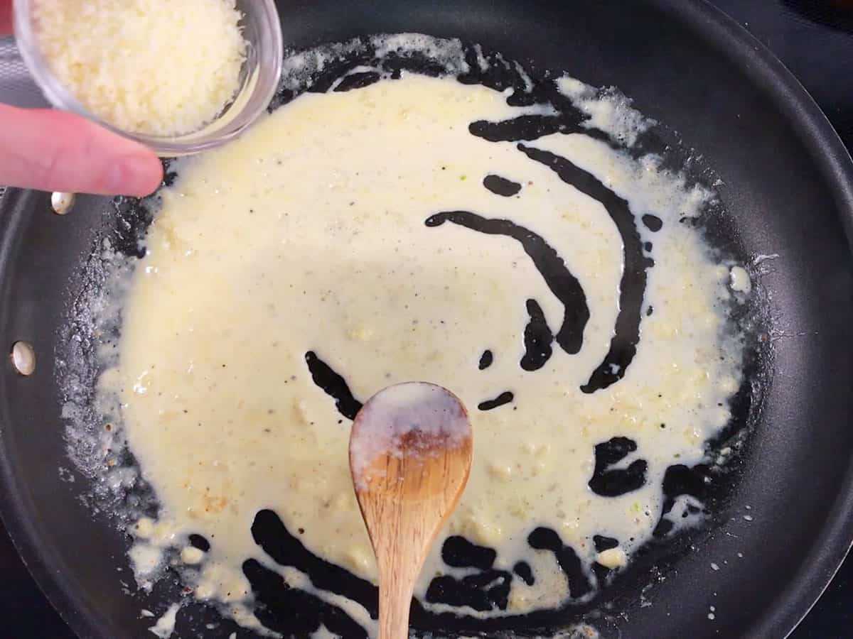 Adding parmesan to the sauce.