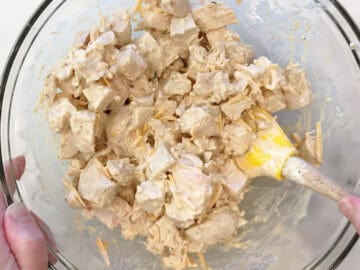 Adding the chicken cubes to the sauce.