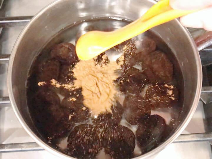 Adding cinnamon to the saucepan.