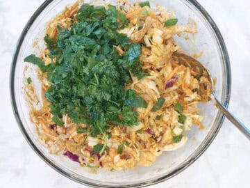 Adding the salad ingredients to the bowl.