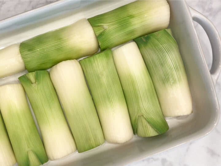 The leeks were arranged in a pan, cut side down.