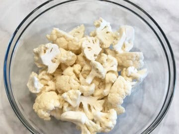 Raw cauliflower florets in a bowl.