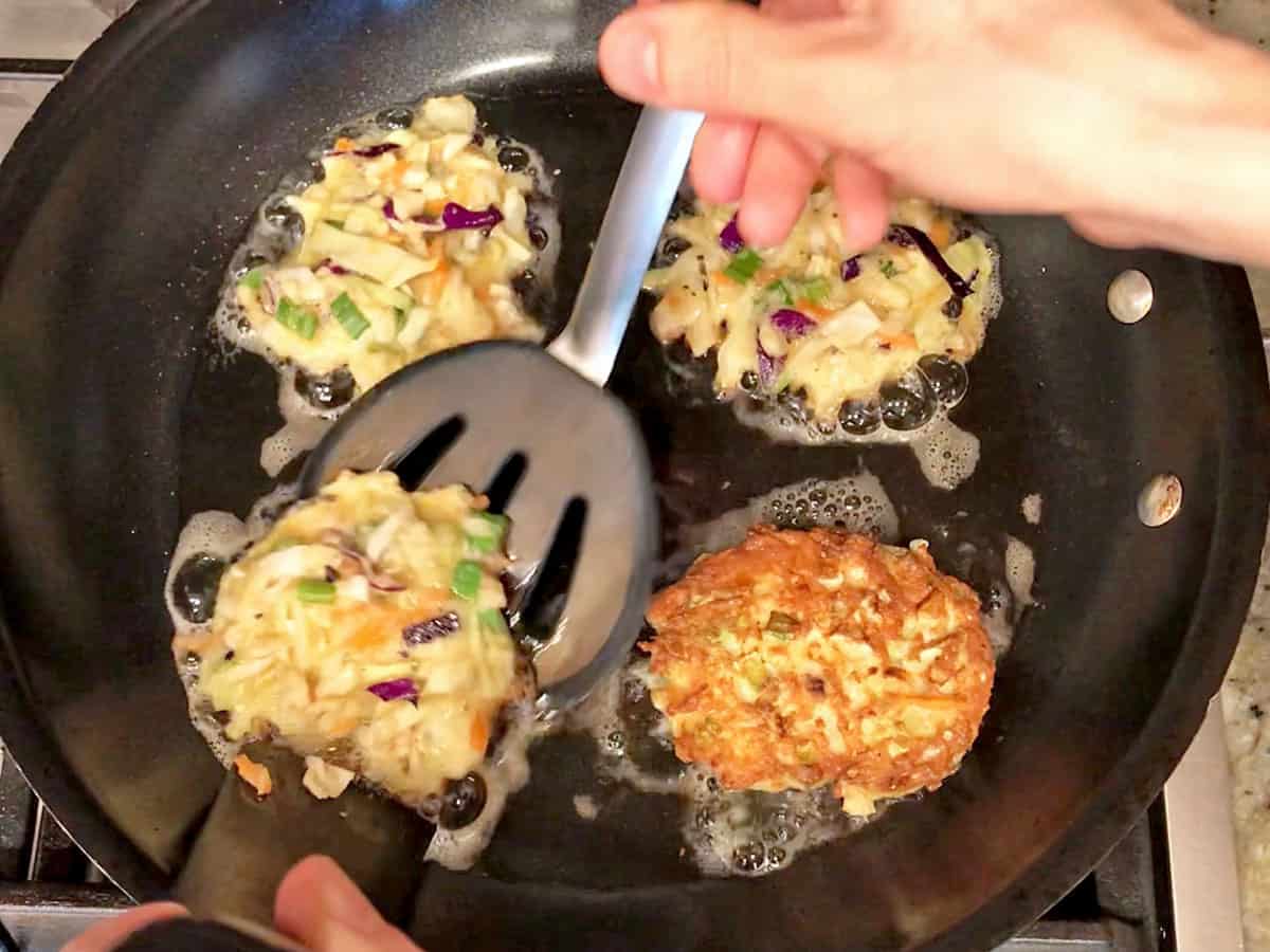 Flipping the pancakes in the skillet.