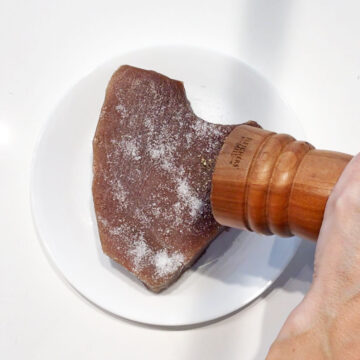 Seasoning the tuna with salt and pepper.