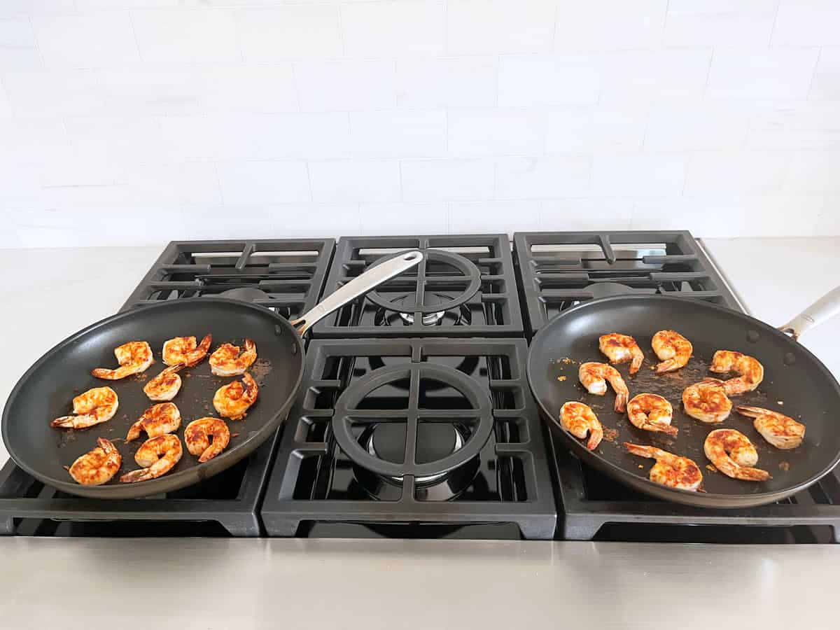 Jumbo shrimp are cooked in two skillets.