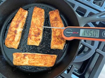 Broiled salmon in the pan has reached 145°F.