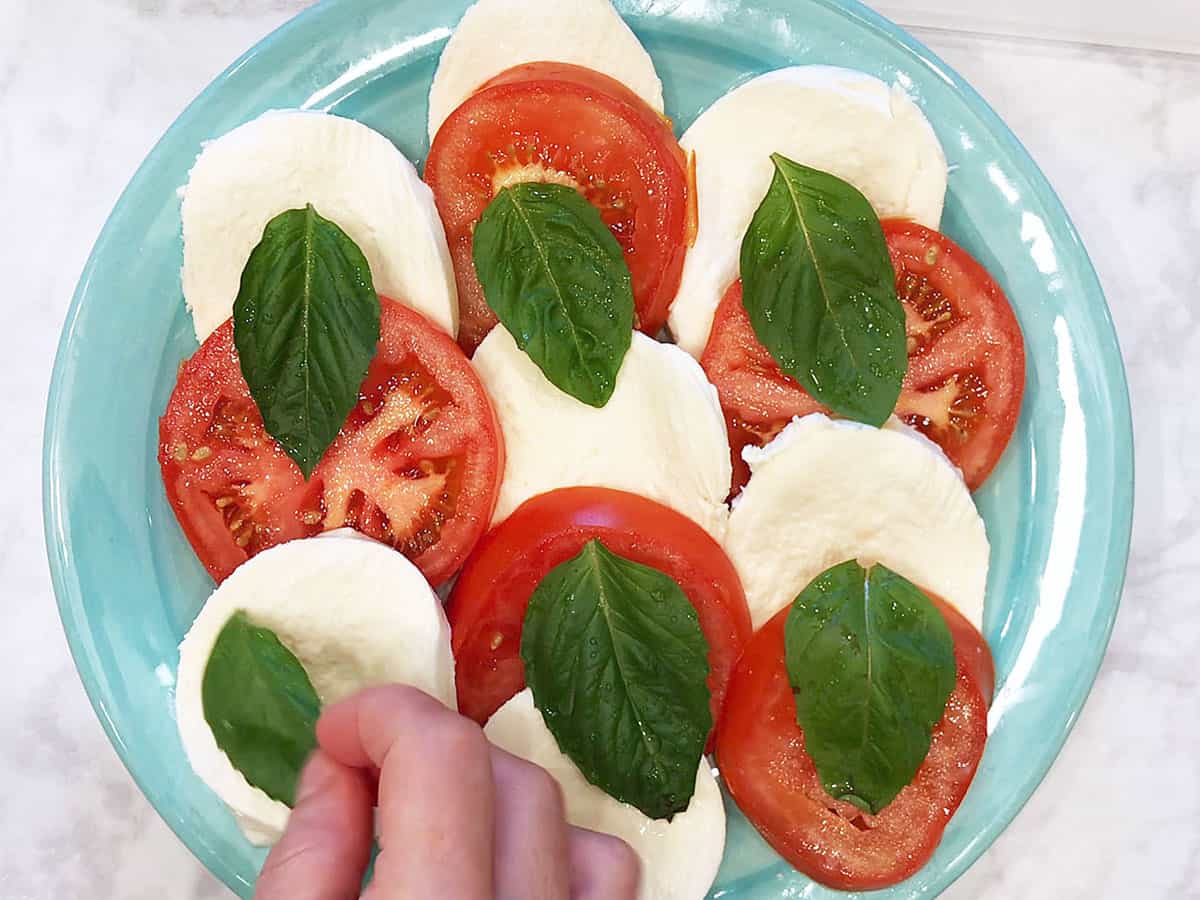Adding basil to the salad.