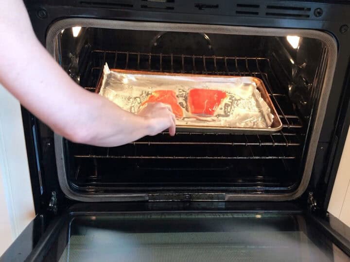 Placing the salmon in the oven.