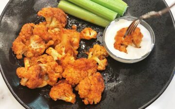 Dipping buffalo cauliflower into blue cheese dressing.
