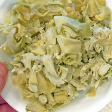 Chopped artichoke hearts on a plate.