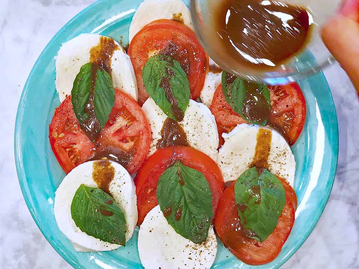 Drizzling the dressing on the salad.