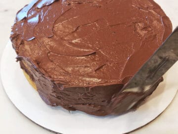 Frosting the cake's sides.