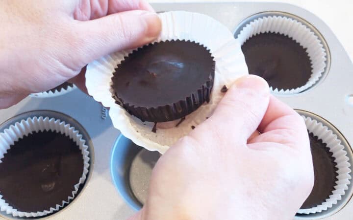 Removing a peanut butter cup from the paper liner.