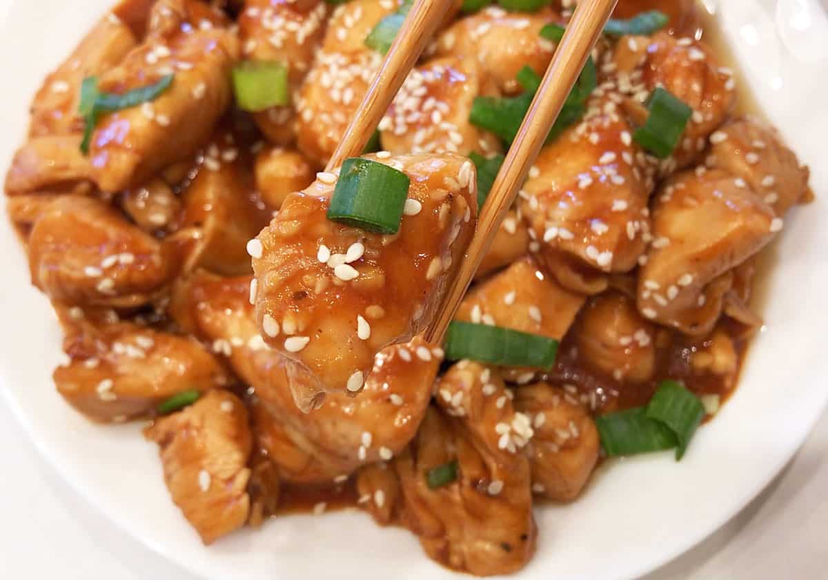 Keto sesame chicken is served with chopsticks.