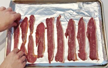 Arranging the bacon slices in the baking sheet.