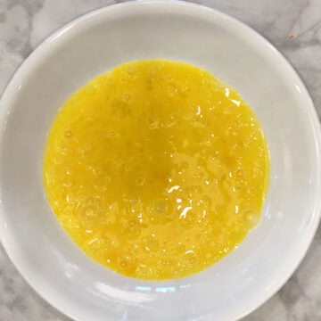 A bowl with whisked eggs.
