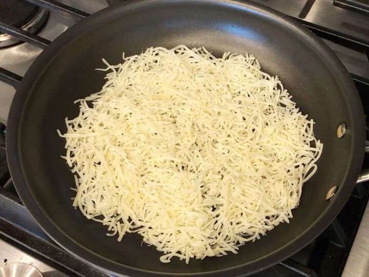 Shredded cheese in a nonstick skillet.