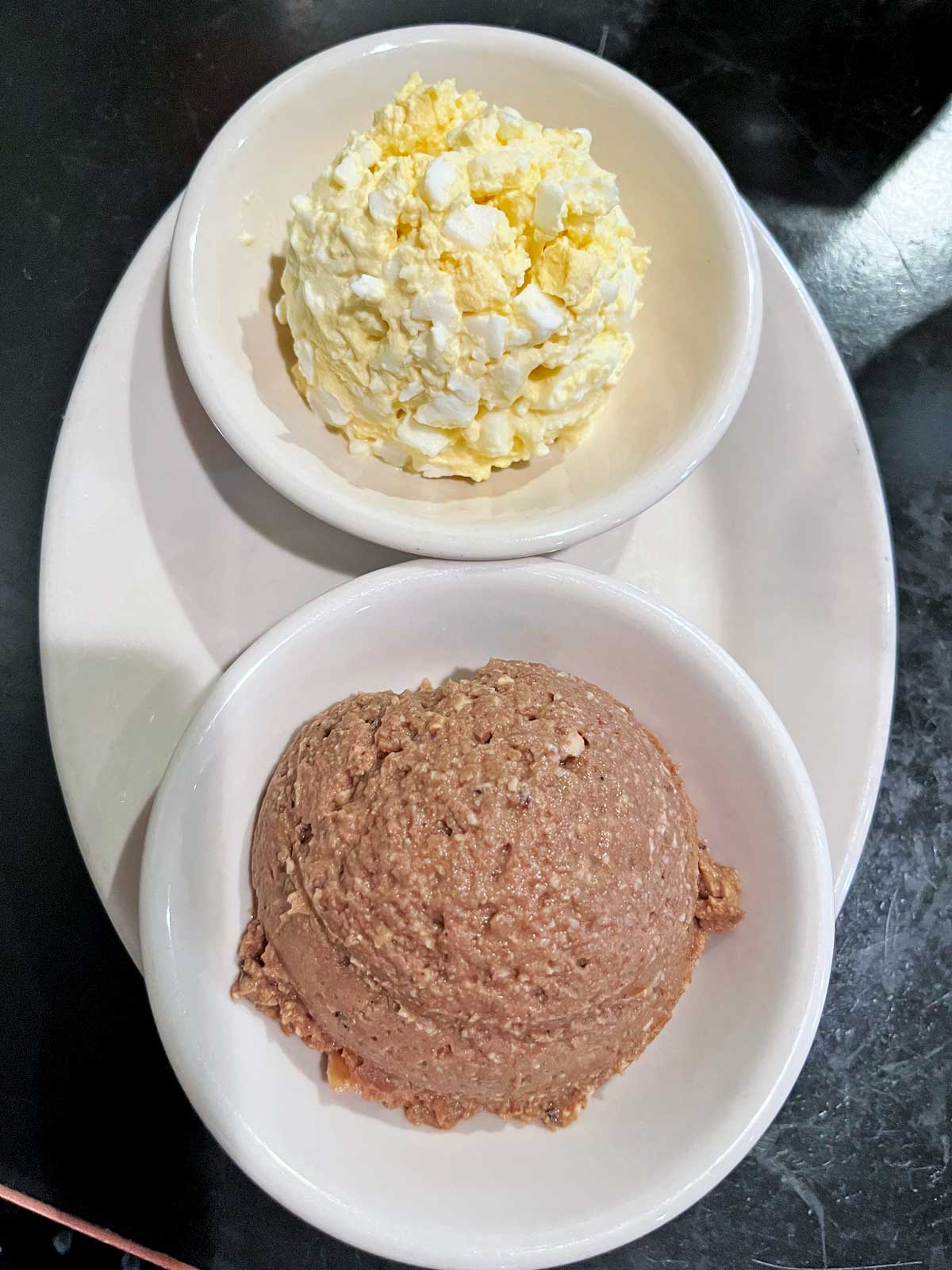 Chopped liver and an egg salad served in bowls.
