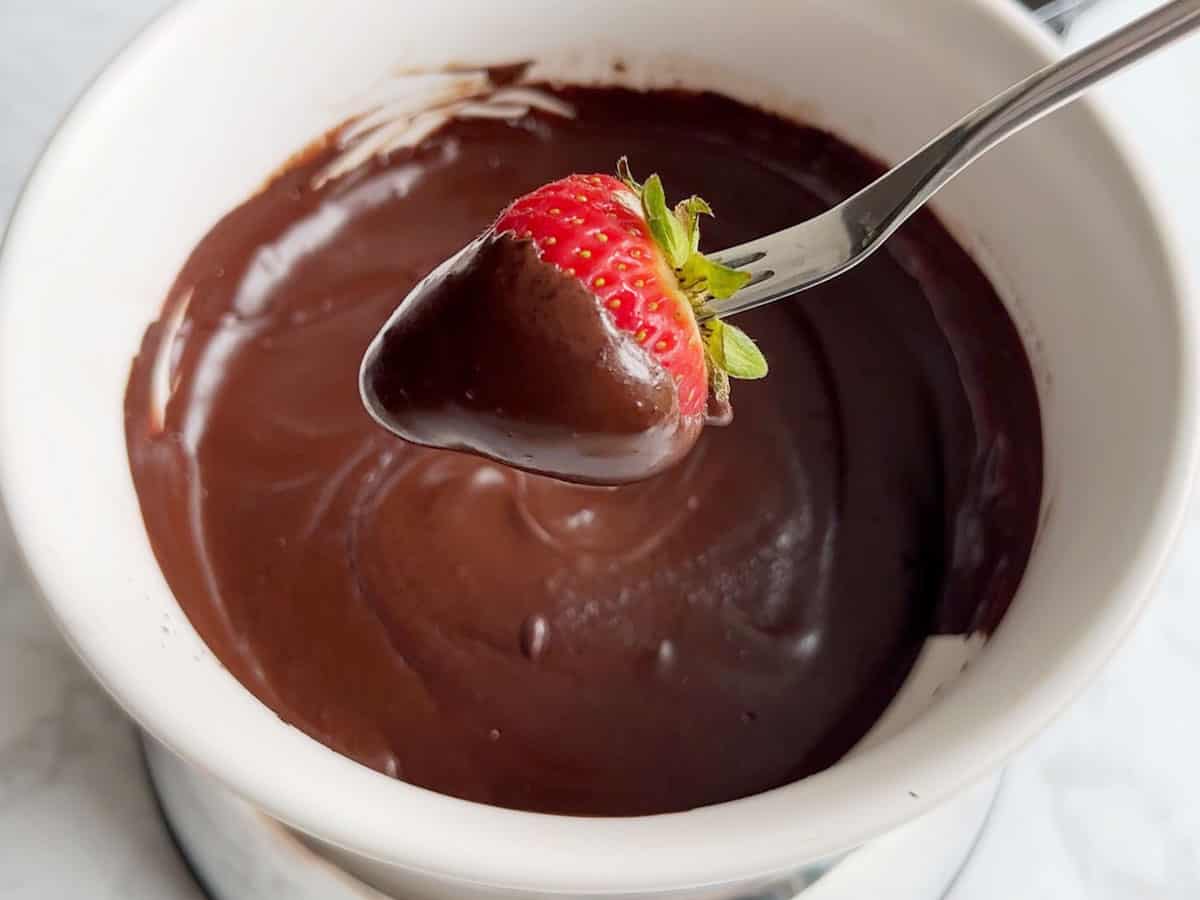 Dipping a strawberry into the fondue.