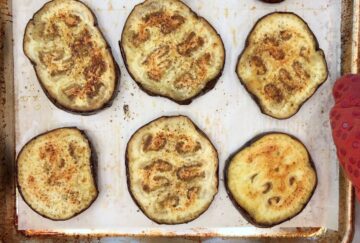Baked eggplant slices on a baking sheet.