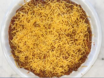 The pie mixture was transferred to the pan and topped with cheese.