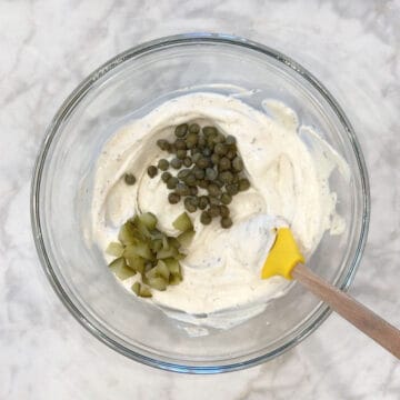 Adding pickles and capers.