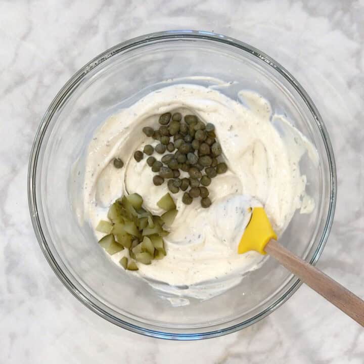 Adding pickles and capers.