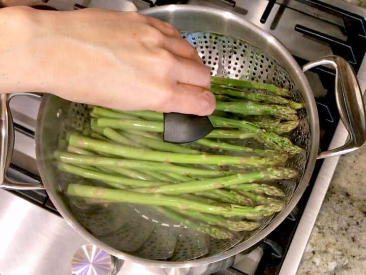 Placing the steamer basket in the saucepan.