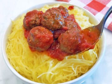 Spaghetti squash and meatballs are served in a white bowl.