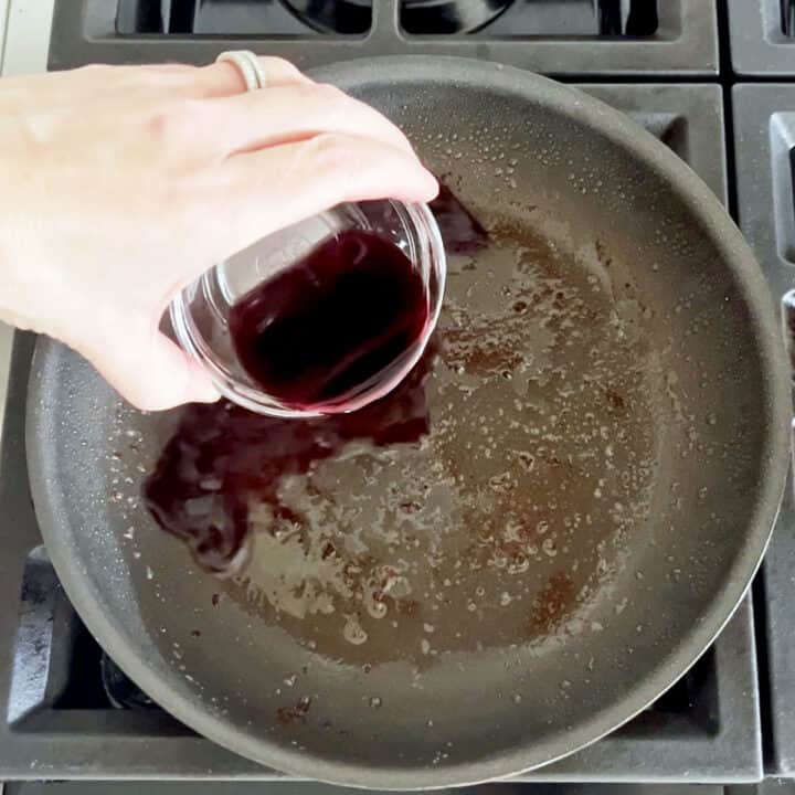 Adding wine to the skillet.