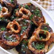 Beef shanks are served on a white platter.