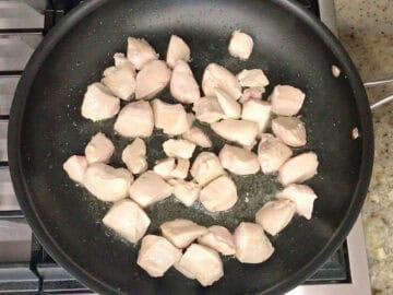 Cooking the chicken in a skillet.