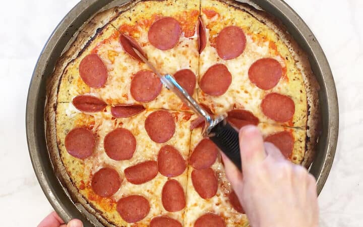 Cutting the pizza into slices.