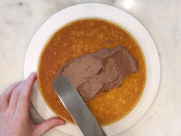 Frosting the first layer of the cake.