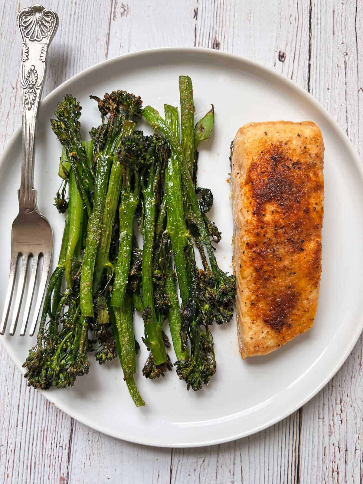 Roasted broccolini is served with salmon.