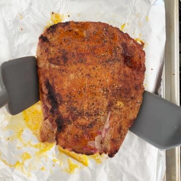Flipping the steak in the pan.