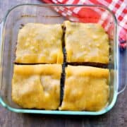 Baked hamburgers in a baking dish, topped with melted cheese.