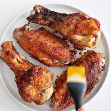 Basting the wings with the pan juices.