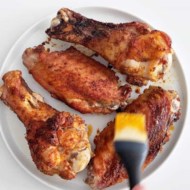 Basting the wings with the pan juices.