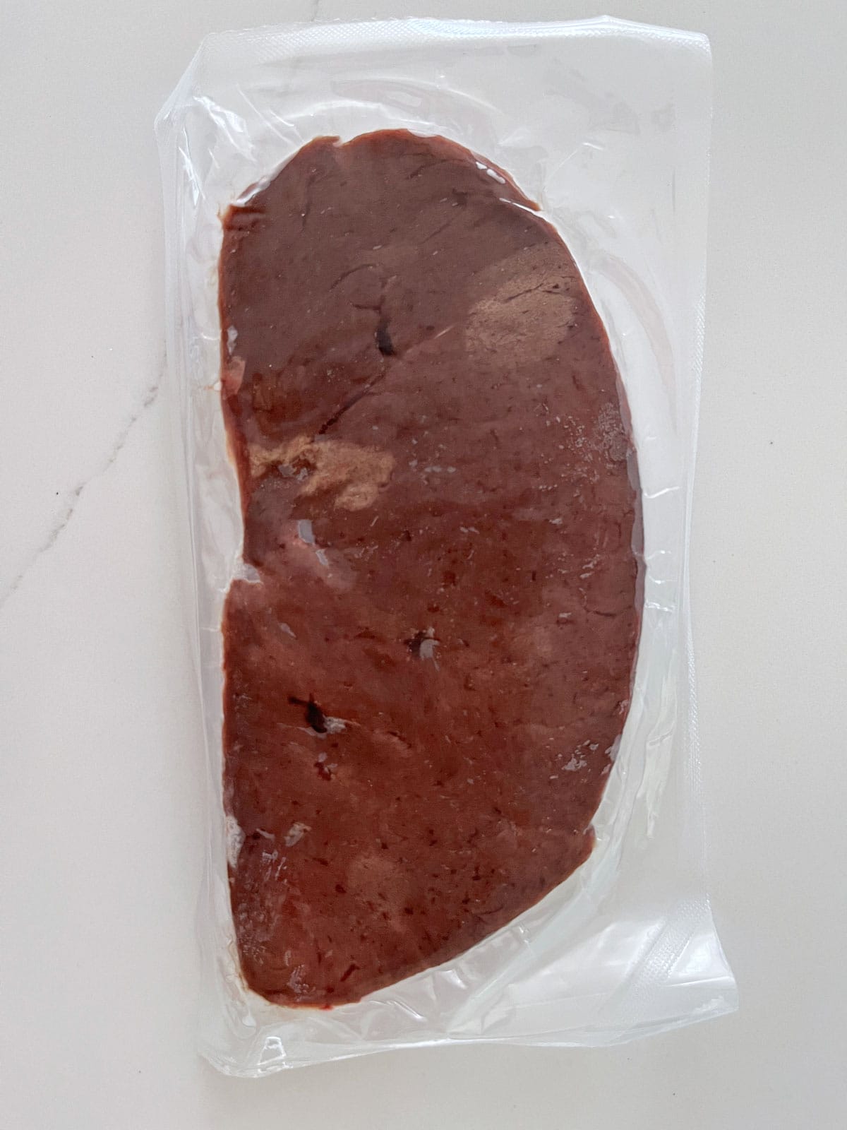 A slice of beef liver in a vacuum pack.