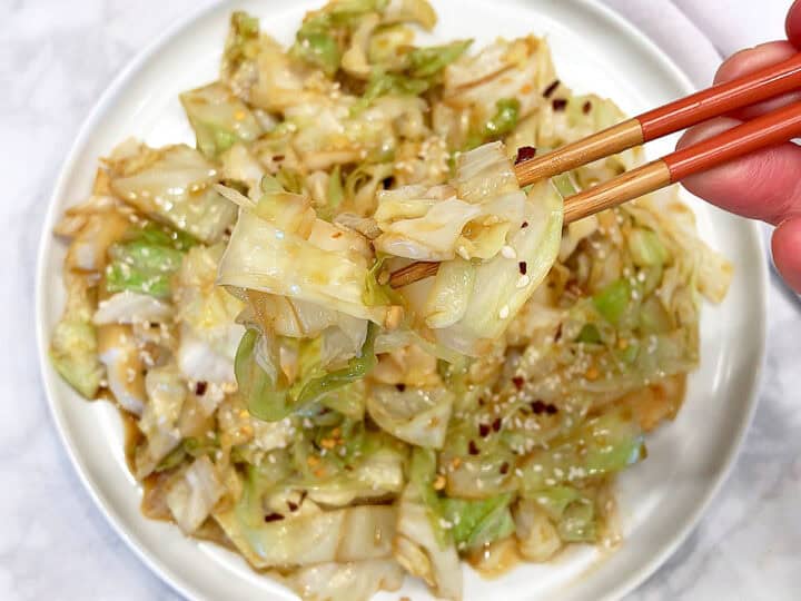 Cabbage stir fry is served with chopsticks.