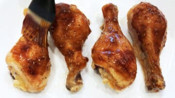 Brushing the chicken with the glaze.