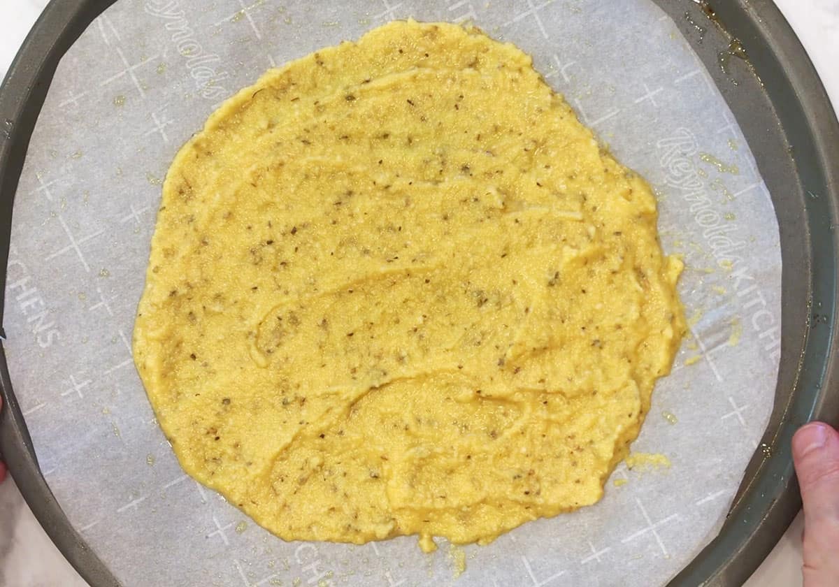 The batter was spread on the pizza pan.