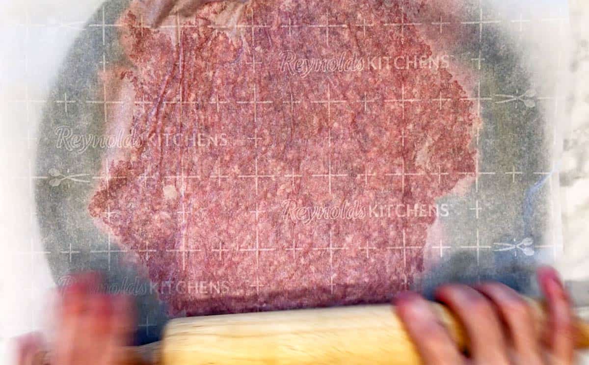 Rolling the meat crust thin.