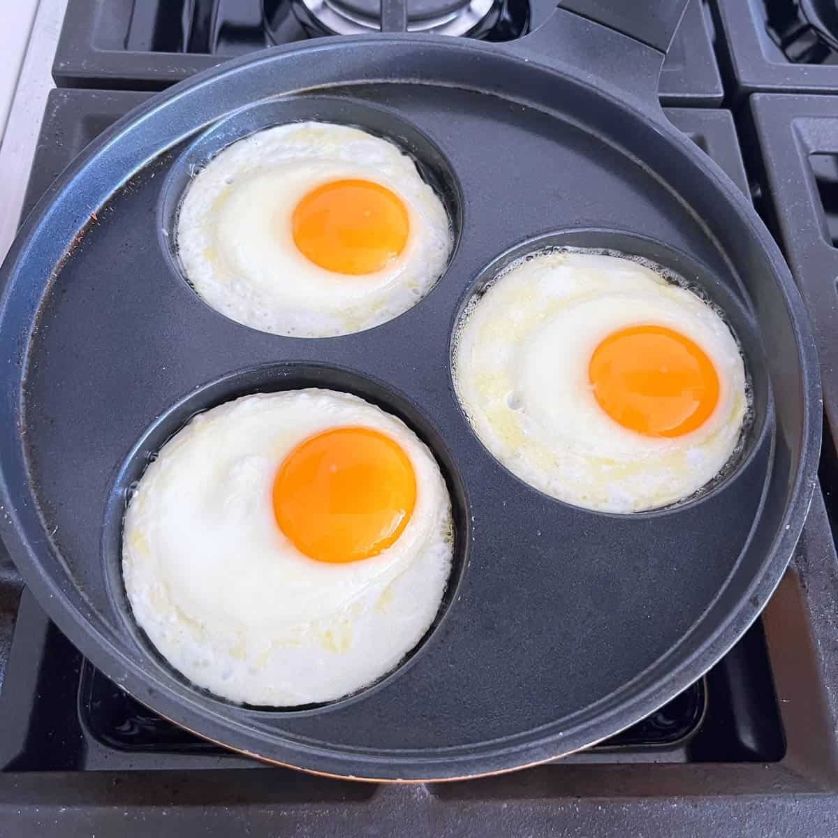 Cooking round eggs in an egg frying pan.