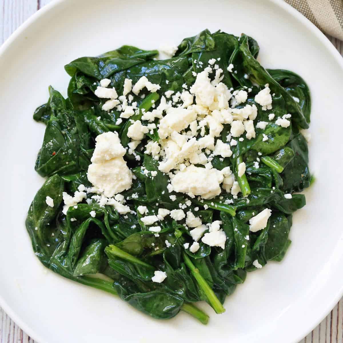 Sauteed spinach is topped with goat cheese.