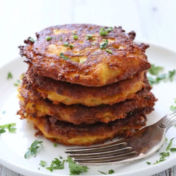 Spaghetti squash fritters are served on a plate with a fork.
